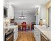 Bright kitchen with stainless steel appliances, marble countertops, and a dining area with red chairs at 566 Viridian St, Englewood, FL 34223