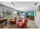 Bright and airy living room featuring wicker chairs, light wood floors, and direct access to the bedroom at 566 Viridian St, Englewood, FL 34223