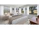 Comfortable bedroom with a plaid blanket, soft carpeting, and an abundance of natural light from surrounding windows at 566 Viridian St, Englewood, FL 34223