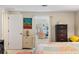 Spacious bedroom with a dresser, nightstand, and comfortable bed, leading into a cozy living area at 566 Viridian St, Englewood, FL 34223