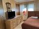 Cozy bedroom with wood dresser, full-size bed, and tv at 5220 Palena Blvd, North Port, FL 34287