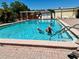 Relaxing refreshing community pool with multiple people enjoying the water at 5220 Palena Blvd, North Port, FL 34287