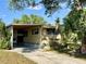 Tan mobile home with carport and mature landscaping at 5220 Palena Blvd, North Port, FL 34287
