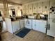 Bright kitchen features white cabinets, appliances, and tile flooring at 5220 Palena Blvd, North Port, FL 34287