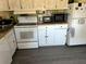 Kitchen featuring white cabinets, appliances, and wood-look countertop at 5220 Palena Blvd, North Port, FL 34287