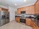 Modern kitchen with wood cabinets, granite countertops, and stainless steel appliances at 14462 Fort Worth Cir, Port Charlotte, FL 33981
