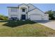 Two-story house with a three-car garage and manicured lawn at 14462 Fort Worth Cir, Port Charlotte, FL 33981