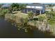 An aerial view of a home with a screened-in pool and lanai next to a canal at 14462 Fort Worth Cir, Port Charlotte, FL 33981