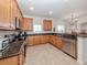 Modern kitchen with wood cabinets, granite countertops, and stainless steel appliances at 14462 Fort Worth Cir, Port Charlotte, FL 33981