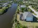 Aerial view of a house with pool, canal views, and lush landscaping at 14462 Fort Worth Cir, Port Charlotte, FL 33981