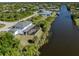Aerial view of a house with a pool and screened lanai overlooking the water at 14462 Fort Worth Cir, Port Charlotte, FL 33981