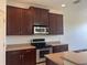 Kitchen features dark wood cabinets, granite countertops, and stainless steel appliances at 1498 Maseno Dr, Venice, FL 34292