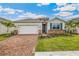 One-story home with brick paver driveway, two-car garage, and landscaped yard at 16090 Highgate St, Port Charlotte, FL 33953