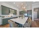 Spacious kitchen features dark green cabinetry, modern appliances, and a large central island at 284 Bocelli Dr., Nokomis, FL 34275