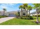 One-story house with gray garage door and tropical landscaping at 15177 Spanish Point Dr, Port Charlotte, FL 33981