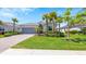 Charming one-story house with lush landscaping and a gray garage door at 15177 Spanish Point Dr, Port Charlotte, FL 33981