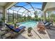 Relaxing pool area with covered patio, lounge chairs, and lush landscaping at 284 Bocelli Dr., Nokomis, FL 34275