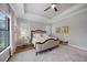 Bright bedroom with a king-size bed, window seating, and hardwood floors at 284 Bocelli Dr., Nokomis, FL 34275