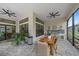Outdoor kitchen with built-in grill, dining table, and ceiling fans at 284 Bocelli Dr., Nokomis, FL 34275