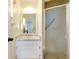 Clean bathroom with a shower, vanity with a marble top, and a mirrored medicine cabinet at 472 Circlewood Dr # L9, Venice, FL 34293