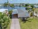Aerial view of mobile home with carport, driveway, and lawn at 109 Lakeview Dr, North Port, FL 34287