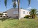Side view of a peach mobile home with landscaping and palm trees at 109 Lakeview Dr, North Port, FL 34287
