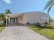 Peach-colored mobile home with carport and landscaped yard at 109 Lakeview Dr, North Port, FL 34287