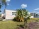 Peach single-story mobile home with a grassy yard at 109 Lakeview Dr, North Port, FL 34287