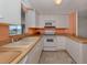 A kitchen with white cabinets, white appliances, and peach walls at 109 Lakeview Dr, North Port, FL 34287