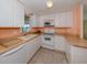 A kitchen with white cabinets, white appliances, and peach walls at 109 Lakeview Dr, North Port, FL 34287