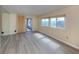 Living room with large windows, sliding door, wood-look flooring, and wall mirror at 109 Lakeview Dr, North Port, FL 34287