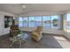 Bright sunroom overlooking a lake with seating area and wood-look floors at 109 Lakeview Dr, North Port, FL 34287