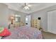 Bedroom with dresser, ceiling fan, and access to another room at 1567 Waterford Dr, Venice, FL 34292
