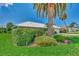 Landscaped yard with palm trees and hedges, showcasing the house at 1567 Waterford Dr, Venice, FL 34292