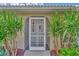 Front entrance with decorative screen door and lush landscaping at 1567 Waterford Dr, Venice, FL 34292