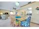 Open concept dining room with glass table and seating for six, adjacent to living room at 1350 Stafford Ln # 1422, Sarasota, FL 34232