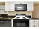 Stylish kitchen with black appliances, granite counters, and white cabinets at 1350 Stafford Ln # 1422, Sarasota, FL 34232