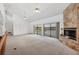 Bright living room with a stone fireplace and access to a patio overlooking a scenic view at 5885 Denison Dr, Venice, FL 34293