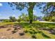 Large grassy yard with a tree and partial view of the house at 5885 Denison Dr, Venice, FL 34293