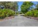 Long driveway leading to a home with lush landscaping on both sides at 5885 Denison Dr, Venice, FL 34293