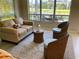 Cozy living room area with comfortable sofa, wicker chairs, and peaceful view at 334 Melrose Ct, Venice, FL 34292