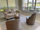 Relaxing living room with comfortable sofa, wicker chairs, and bright outdoor view at 334 Melrose Ct, Venice, FL 34292