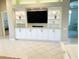 Living room featuring custom built-in shelving, display lighting, and media center at 334 Melrose Ct, Venice, FL 34292