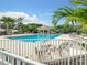 Beautiful outdoor swimming pool surrounded by lounge chairs and lush tropical landscaping at 334 Melrose Ct, Venice, FL 34292