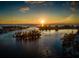 Aerial view of a beautiful sunset over calm water with boat at 688 Back Nine Dr, Venice, FL 34285