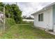 Grass yard with a side view of the house at 3460 Shamrock Dr, Venice, FL 34293