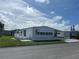 White single-wide manufactured home with carport and small deck at 923 Cortina Blvd, Venice, FL 34285