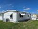 Side view of the manufactured home with a deck and AC unit at 923 Cortina Blvd, Venice, FL 34285