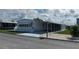 Front view of a white manufactured home with a carport and landscaping at 923 Cortina Blvd, Venice, FL 34285