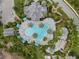 Aerial view of a resort style pool surrounded by palm trees and tropical landscaping at 11112 Mc Dermott Ct, Englewood, FL 34223